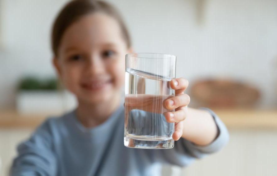 Young boy holding a glass of water